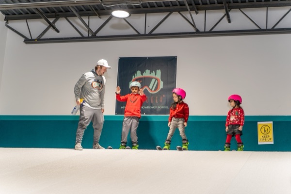Instructor high-fiving a young skier at Shredder Central Park